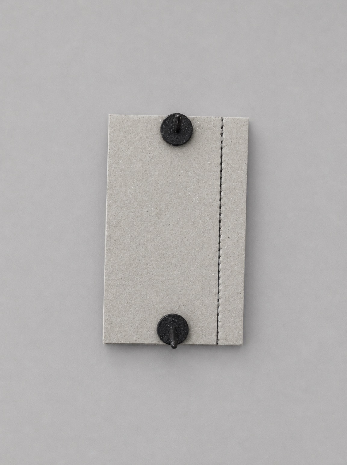 Back of a narrower trimmed M-Plate showing two fasteners and perforated guide