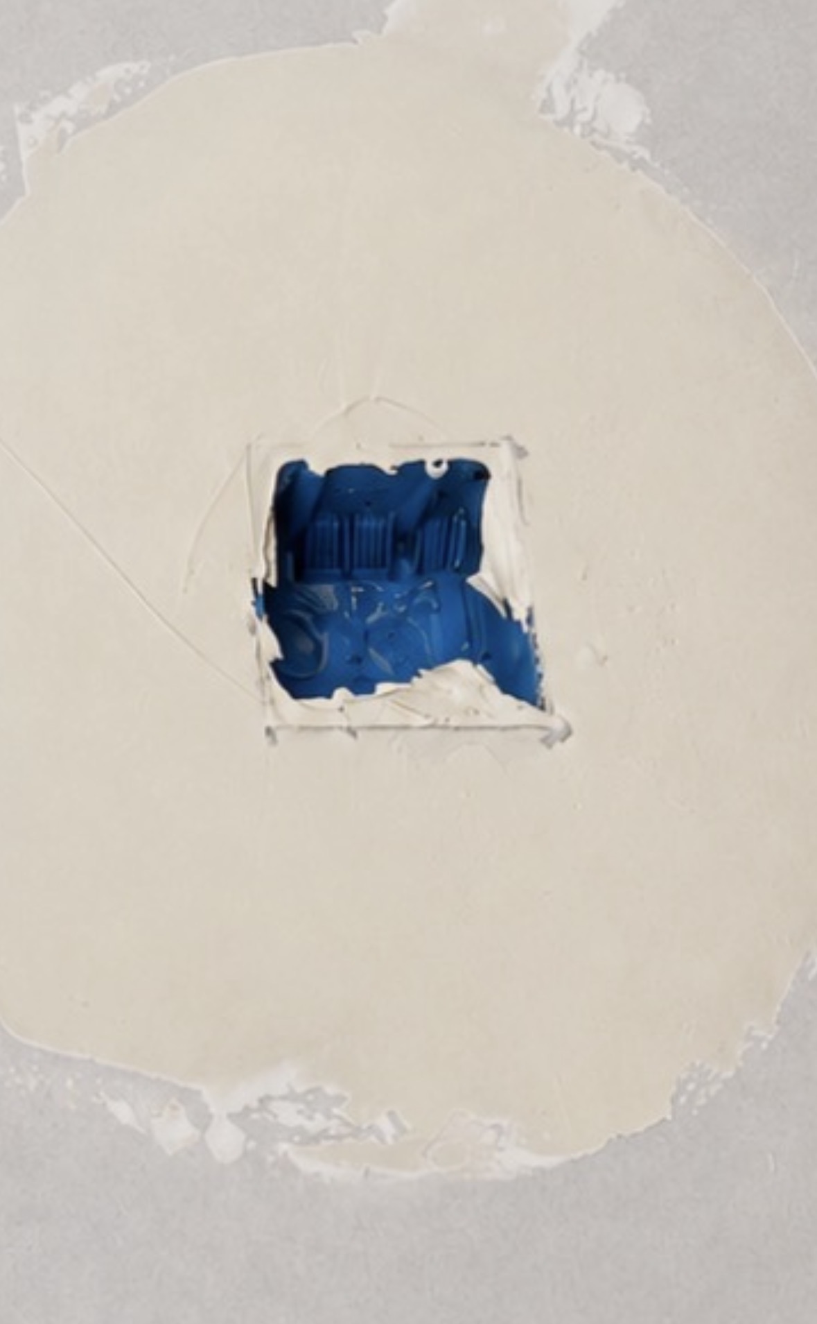 Open electrical box with excess drywall compound around and inside the opening